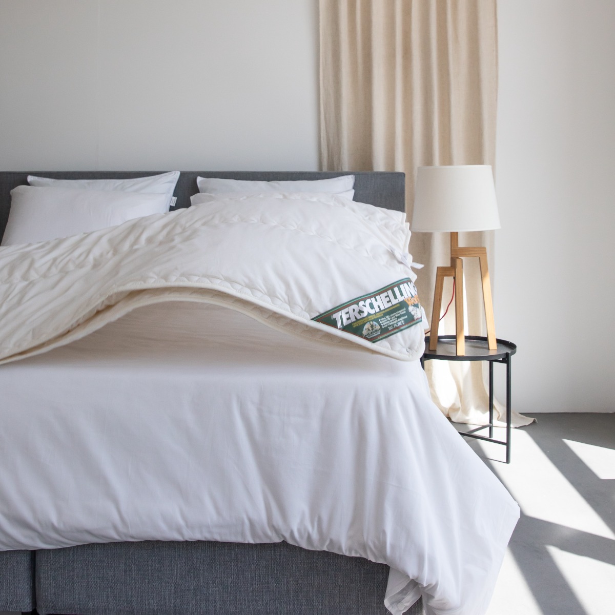 Rustige slaapkamer met opgemaakt bed, natuurlijk licht en zachte materialen